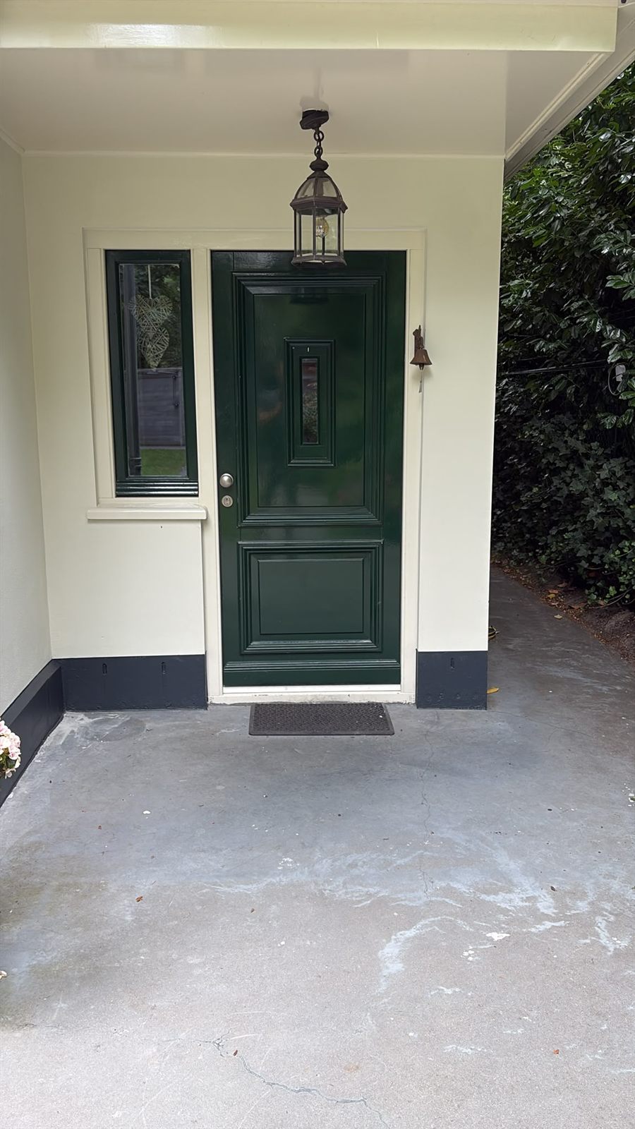 Klassieke donkergroene voordeur met paneelwerk en zijlicht